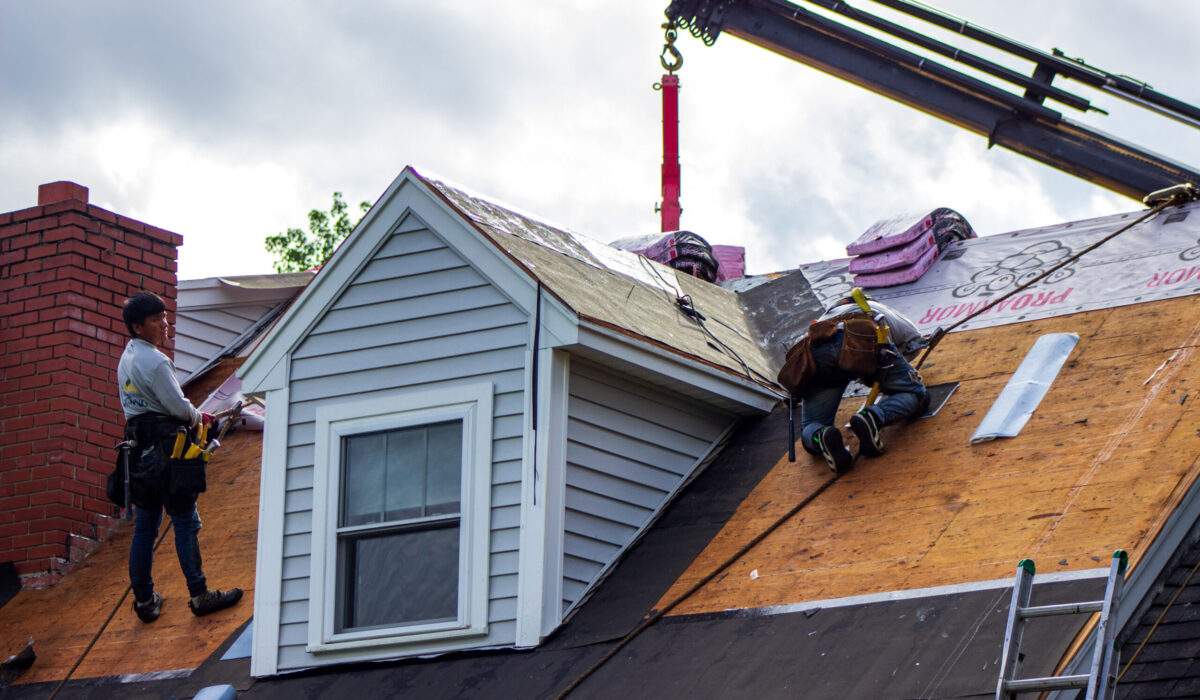 Roofing contractors doing spring roof work and roof repairs on suburban home.