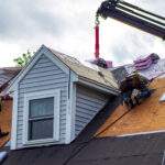 Roofing contractors doing spring roof work and roof repairs on suburban home.