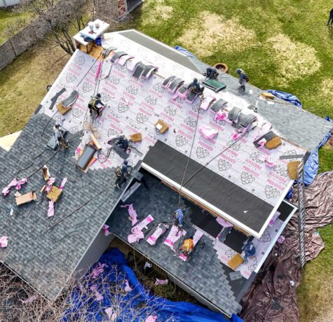 Roofing contractors putting roofing underlayment in place for roof protection.