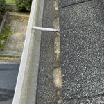 Asphalt shingle granule loss in the gutters.