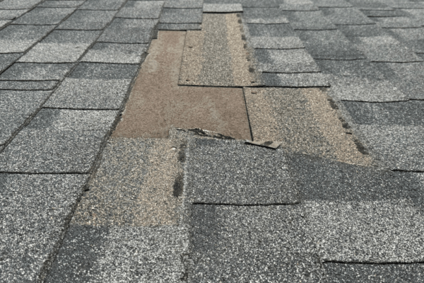 Roof damage: missing shingles due to strong windstorm.