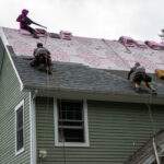 Roofing contractors in Vermont working on roofing upgrades to asphalt shingles roof improve home market value.
