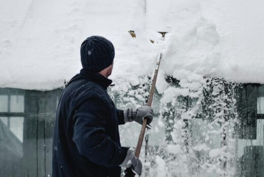 Vermont homeowner removing snow from roof to prevent winter roofing problems.